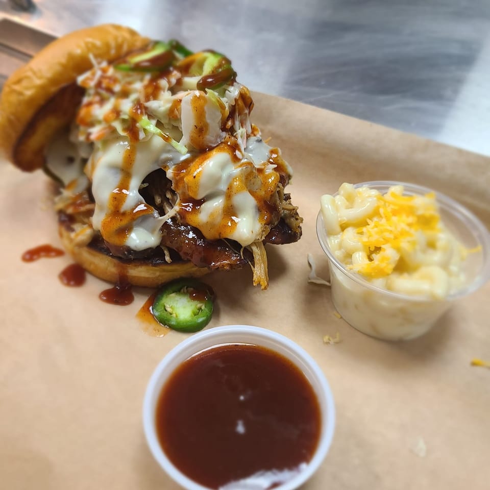 Stuboy's BBQ pulled pork sandwich with coleslaw, cheese, jalapeños, mac and cheese, and BBQ sauce.